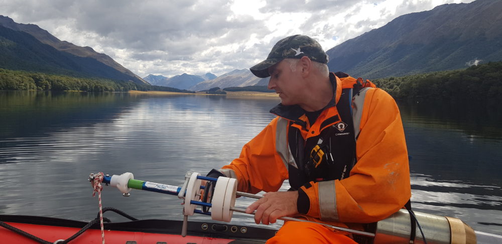 Marcus measuring sediment core samples from a lake